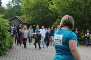 Auf dem Bild erkennt man eine Teamerin, welche das Startsignal zum Loslaufen gibt.