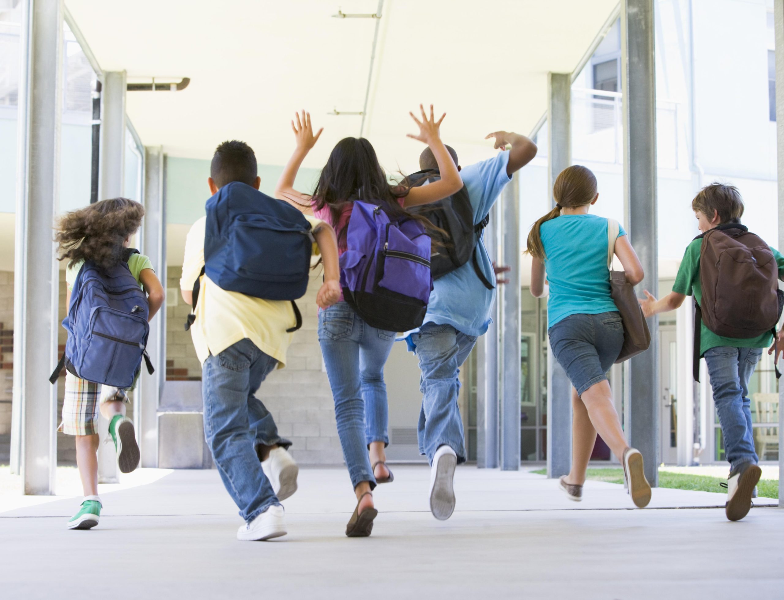 Schülerinnen und Schüler laufen in die Schule