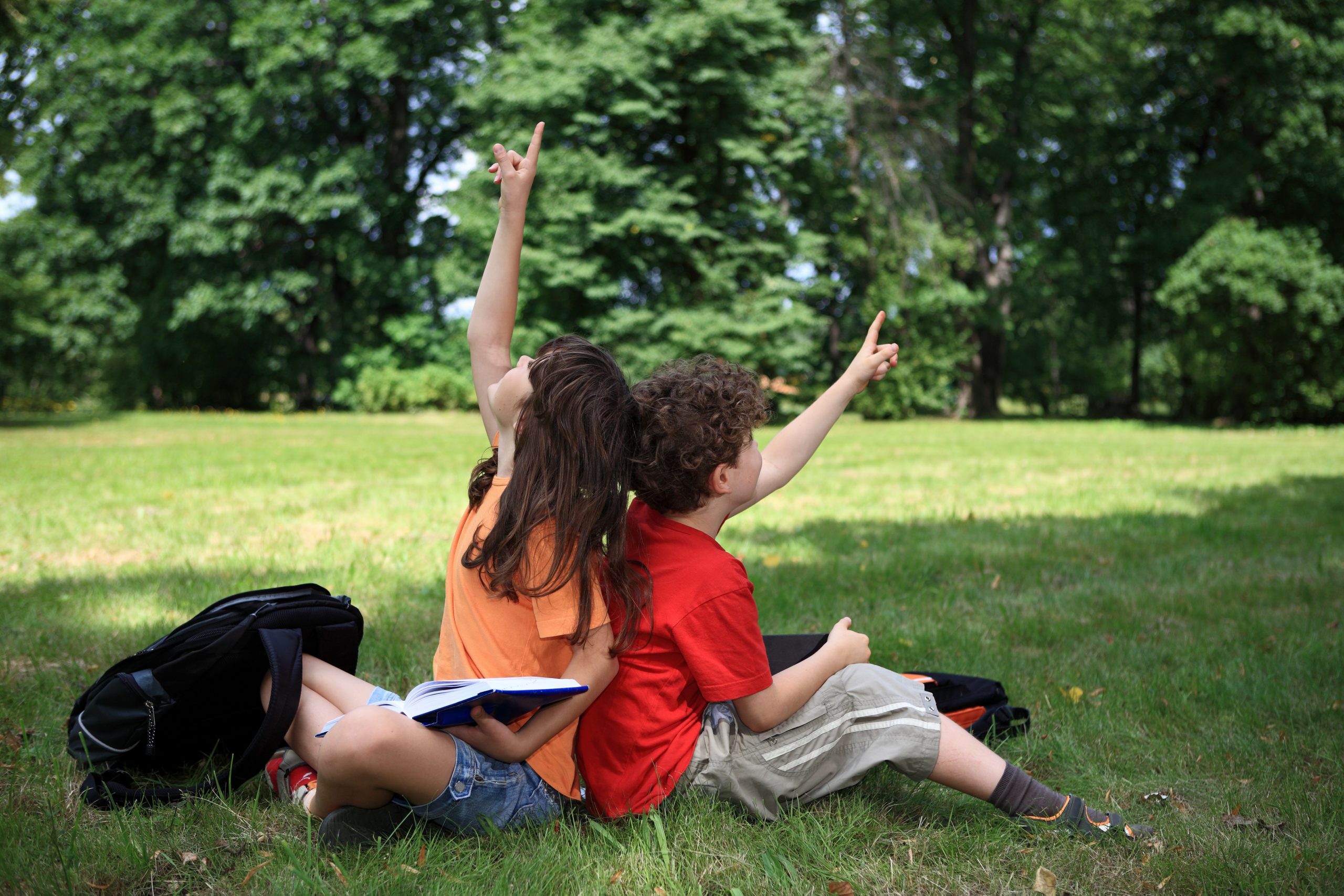 Zwei Schüler sitzen auf einer Wiese