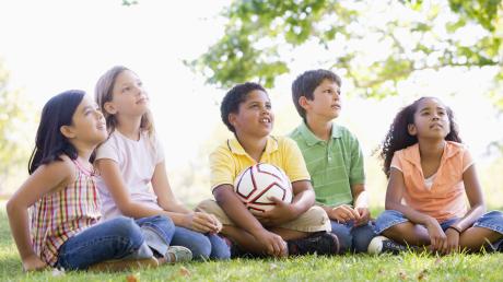 Fünf Kinder sitzen draußen